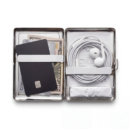 Porte-cartes en métal ArtCase ouvert avec les essentiels du week-end à l'intérieur
